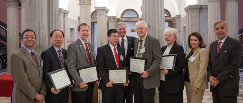 The banner features, from left to right, Prakash Nagarkatti, Chuanbing Tang, Hans-Conrad zur Loye, Yiming Ji, Henry McMaster, Bert Ely, Dr. Carol Jantzen of the Savannah River National Laboratory, USC Provost Joan T.A. Gabel and USC President Harris Pastides.